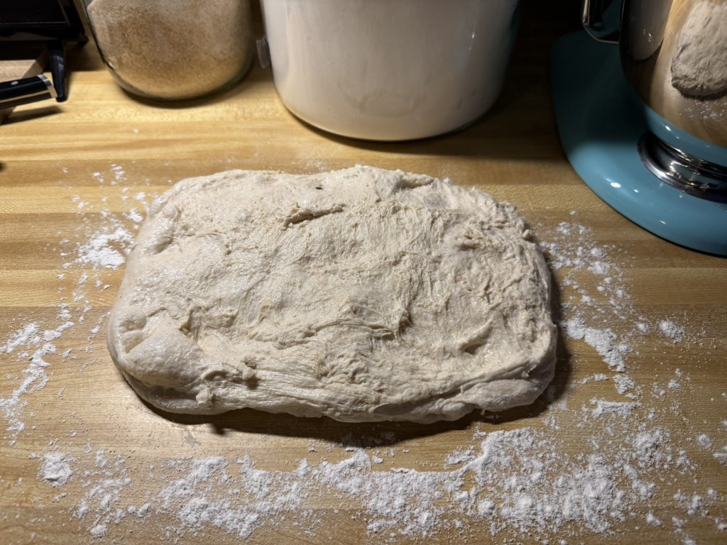 raw dough on the counter stretched into a rectangular shape.